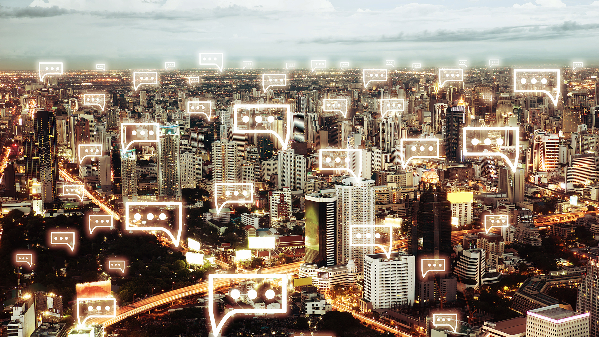 Communication chat icon above cityscape in the night light of the city.